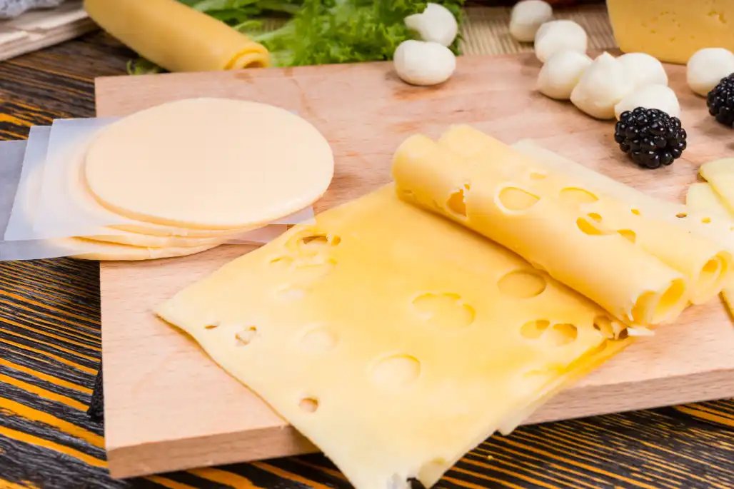 e: Beberapa lembar keju slice di atas talenan. Source: user33154880/Freepik